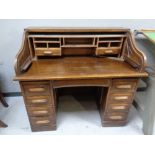 An Edwardian oak roll-topped double-pedestal desk.