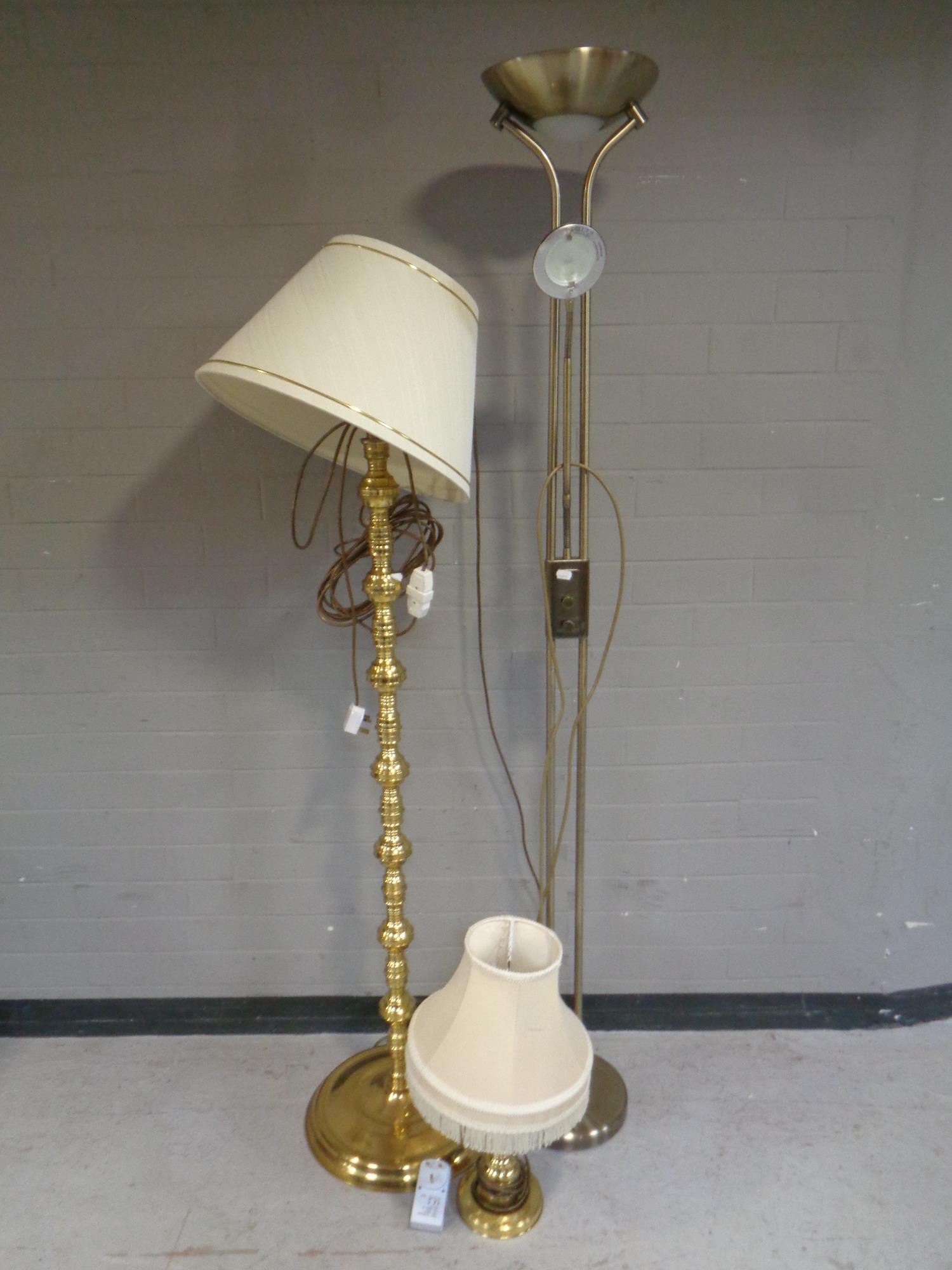 A brass standard lamp with shade together with matching table lamp with shade and a further