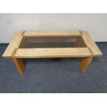 A contemporary oak rectangular coffee table with glass inset panel