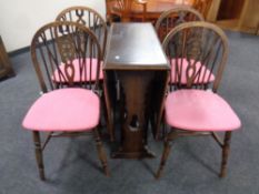An oak drop leaf dining table together with a set of four wheel back chairs