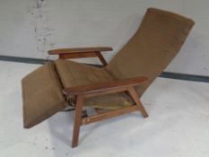 A mid 20th century teak framed reclining armchair with foot rest.
