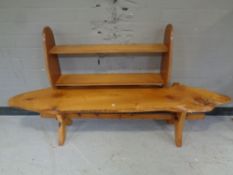A rustic plank top bench on pine X-framed base together with a teak wall shelf.