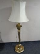 A brass standard lamp with cast rams head and acanthus leaf detail,