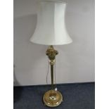 A brass standard lamp with cast rams head and acanthus leaf detail,