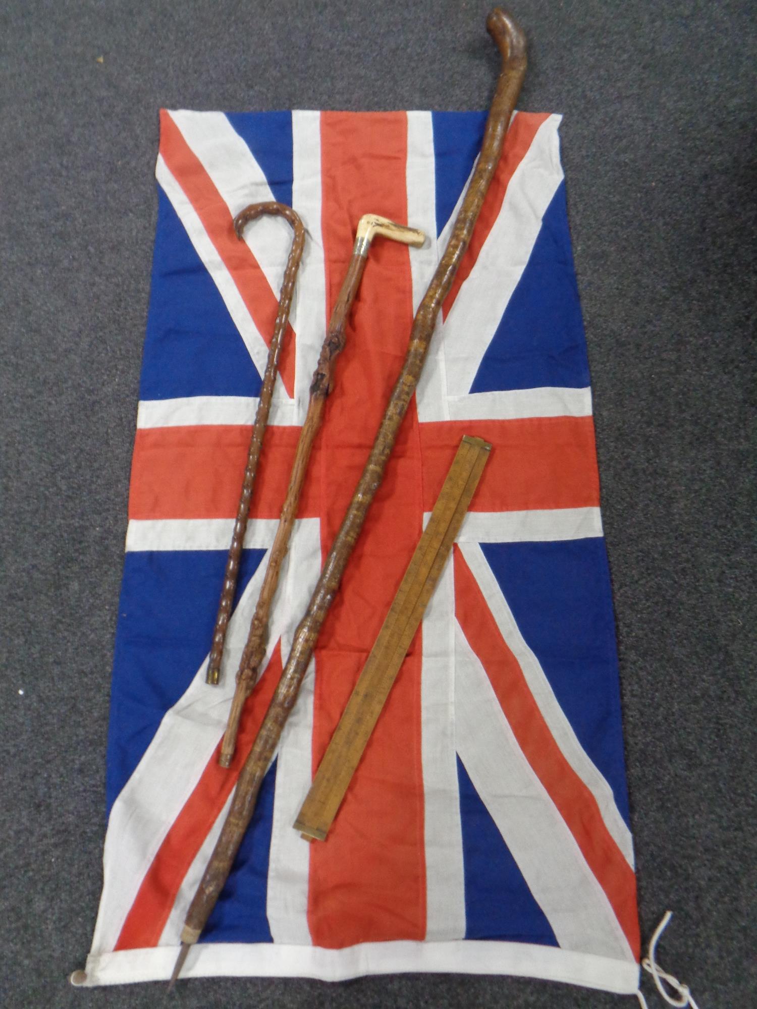 A Union flag together with 3 walking sticks and an extending wooden ruler