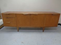 A mid 20th century teak Mcintosh furniture triple door cocktail sideboard fitted three drawers on