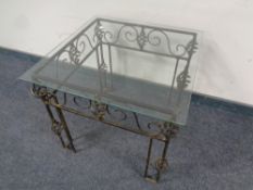 A contemporary wrought metal and glass lamp table