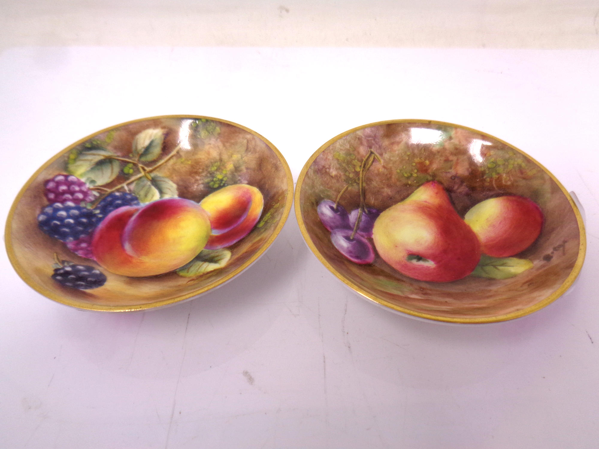 Two Royal Worcester gilt-rimmed small circular dishes, with hand painted Fruit decoration,