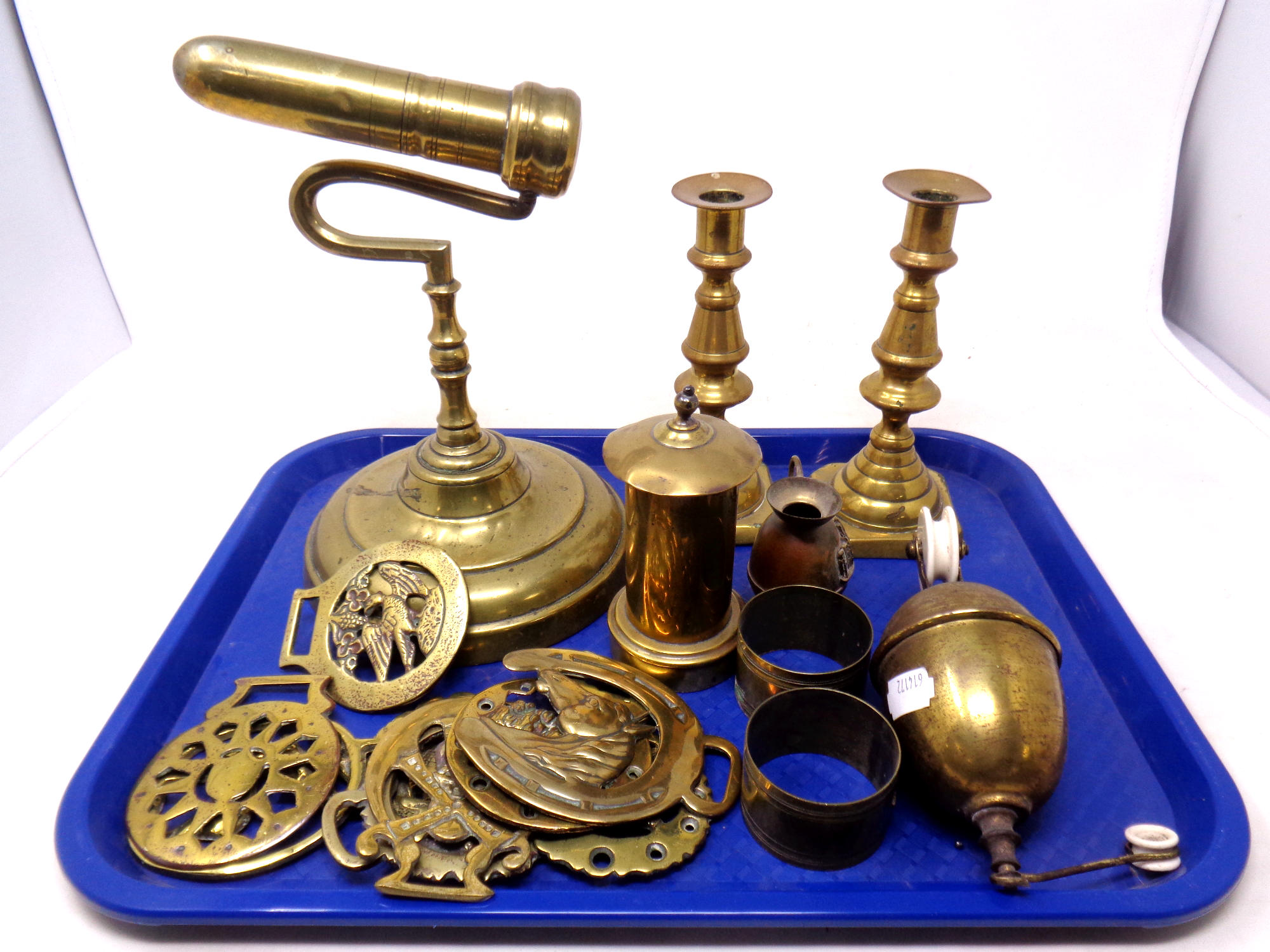 A tray containing antique and later brass ware to include horse brasses, brass weight,