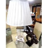 A contemporary metal and glass table lamp with shade together with a further contemporary figure,