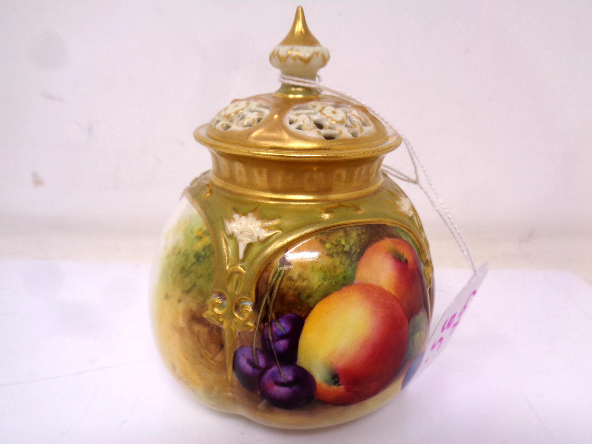 A Royal Worcester gilt-rimmed bulbous lidded pot, with hand painted Apple,