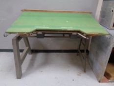 A industrial draftsmen's table on metal legs.