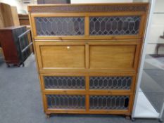 A mahogany four-height stacking bookcase with leaded glass doors.