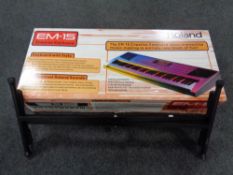 A Roland EM-15 creative keyboard together with keyboard stand