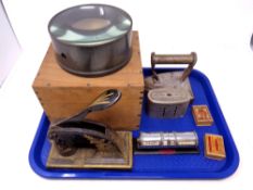 A tray containing a 19th century cast iron punch, large lens in a wooden crate,