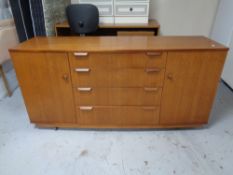 A mid 20th century teak double door sideboard fitted four drawers on casters.