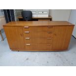 A mid 20th century teak double door sideboard fitted four drawers on casters.