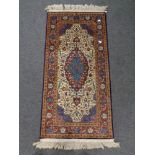 A silk-piled fringed Persian rug.
