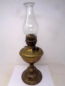 An antique brass embossed Duplex oil lamp with chimney