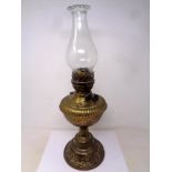 An antique brass embossed Duplex oil lamp with chimney