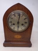 A late 19th century inlaid mahogany arch top eight day mantel clock with silvered dial