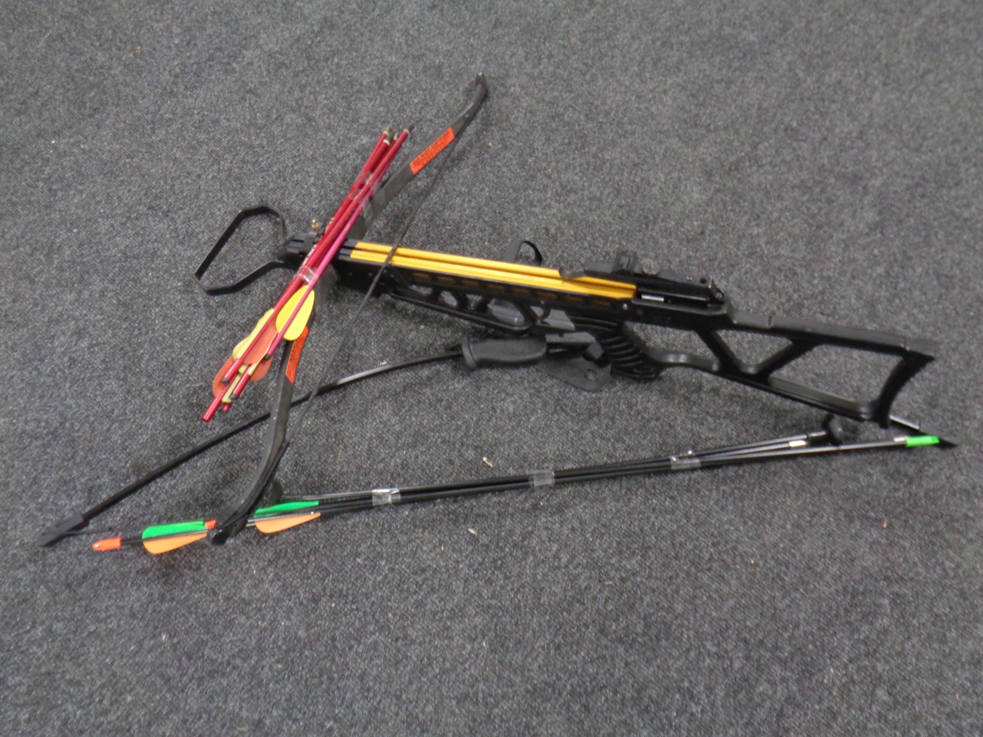 A crossbow with bolts together with an archery bow with arrows
