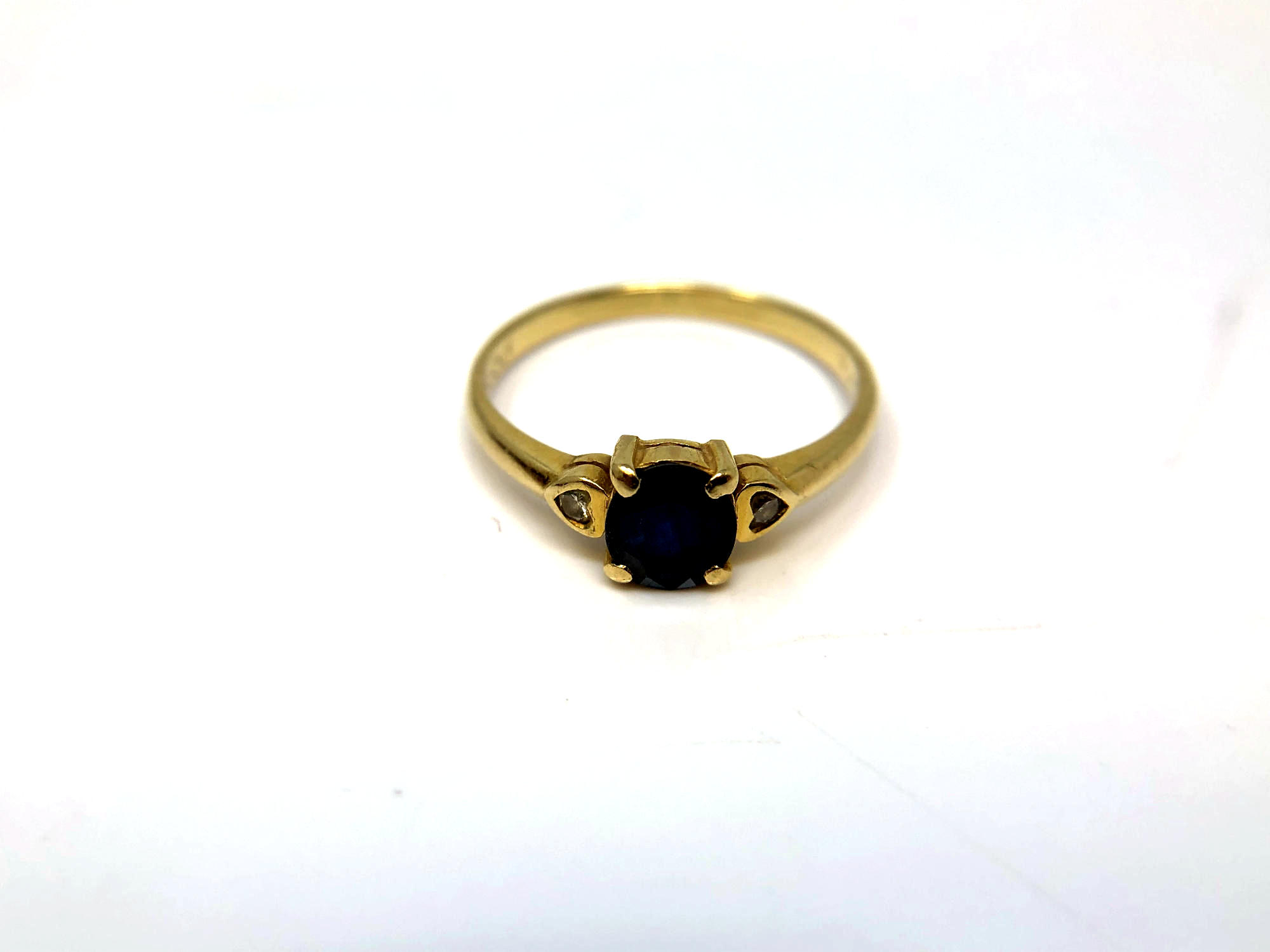 An 18ct yellow gold sapphire and two stone diamond ring, size M/N, 2.1g.