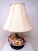 A Moorcroft Pink Magnolia bulbous table lamp with shade on wooden stand. Lamp base 18.