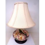 A Moorcroft Pink Magnolia bulbous table lamp with shade on wooden stand. Lamp base 18.