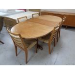 A mid 20th century teak oval G plan extending dining table fitted a leaf together with a set of