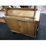 A carved oak two door side cabinet