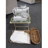 A mid 20th century wicker folding table together with a Pfaff Hobbymatic 917 sewing machine,