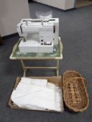 A mid 20th century wicker folding table together with a Pfaff Hobbymatic 917 sewing machine,