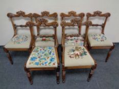 A set of six carved rosewood dining chairs with embroidered seat pads