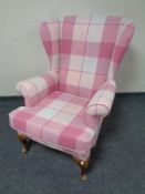 A wingback armchair in checkered pink upholstery