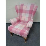 A wingback armchair in checkered pink upholstery