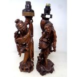 A pair of carved Chinese hardwood figural table lamps