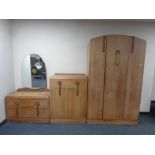 An early 20th century oak three piece bedroom suite comprising single door wardrobe,