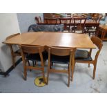 A mid 20th century teak extending dining table fitted a leaf together with a set of six teak chairs