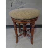 A Victorian beech circular piano stool