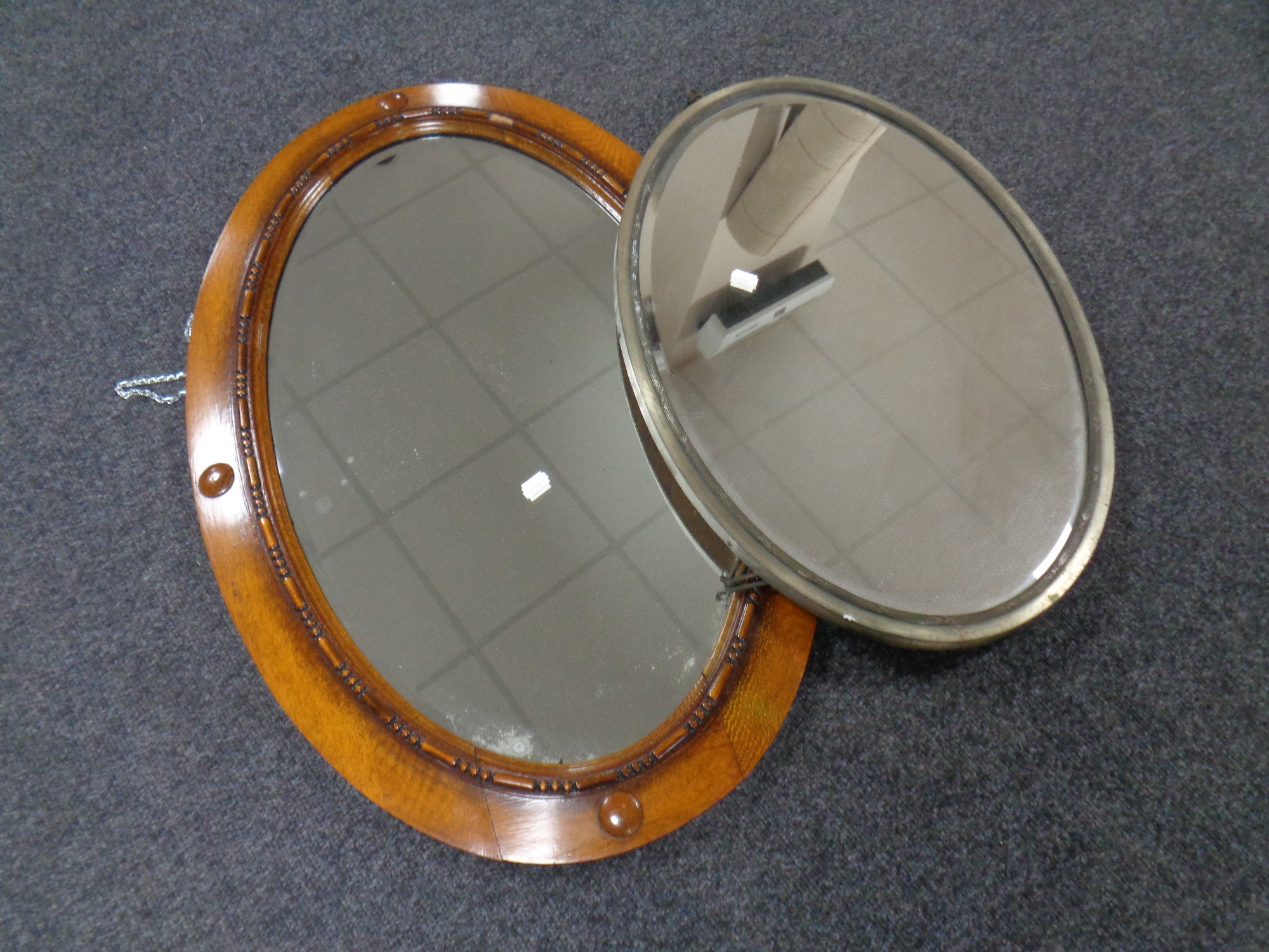 An Edwardian oak framed bevel edged mirror together with a similar metal framed mirror
