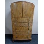 An early 20th century burr walnut dome top chest of five drawers fitted cupboards above