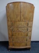An early 20th century burr walnut dome top chest of five drawers fitted cupboards above