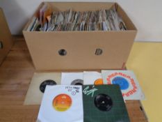 A box containing a large quantity of vinyl 7" singles to include T-Rex, Simon and Garfunkel,