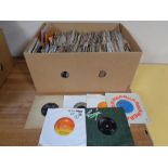 A box containing a large quantity of vinyl 7" singles to include T-Rex, Simon and Garfunkel,