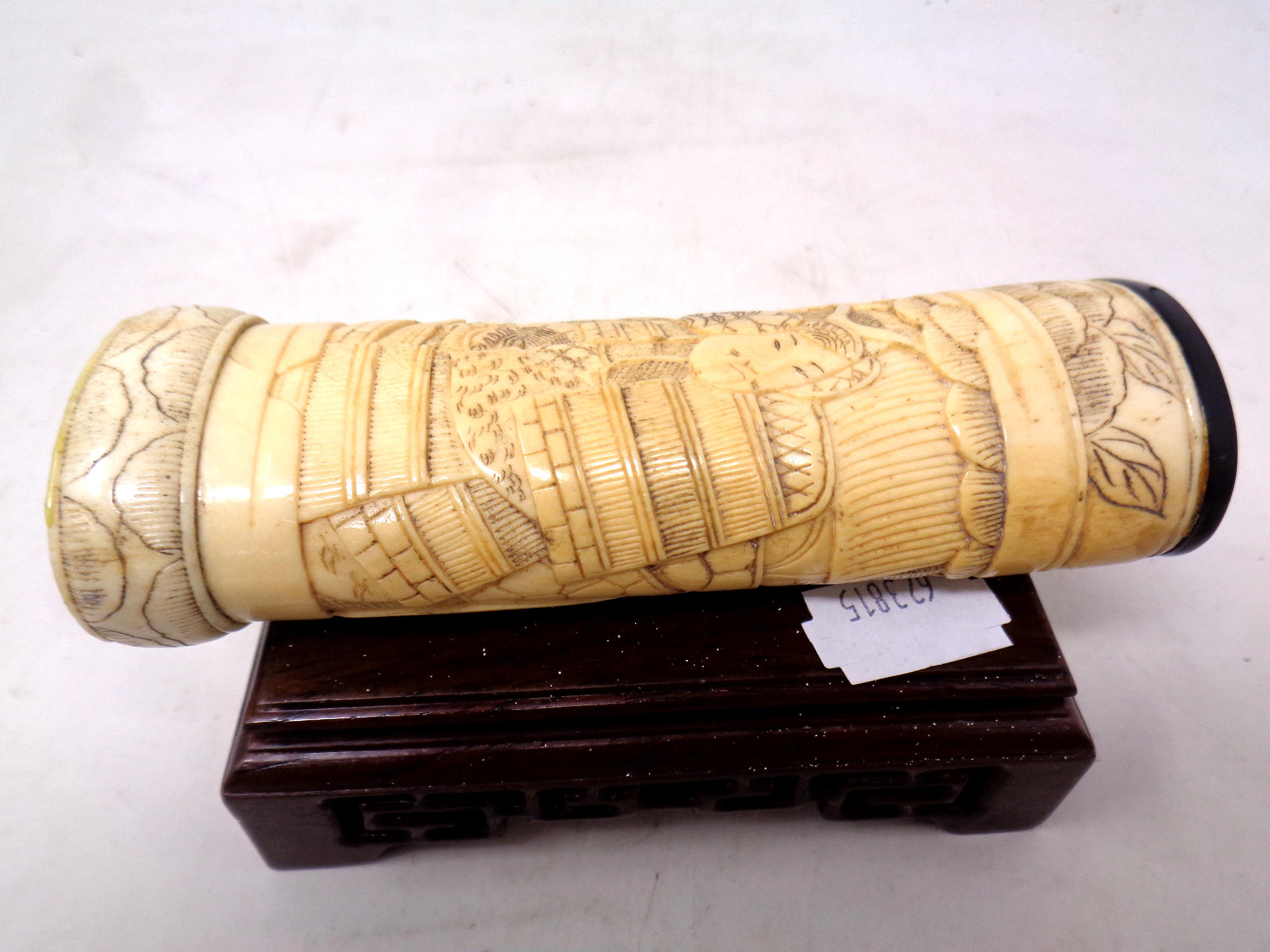 Three carved Japanese ivory and pen work netsuke on wooden stand together with a carved bone sword - Image 2 of 3