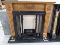 A cast iron Art Nouveau tiled fire insert with carved oak surround and black marble hearth.