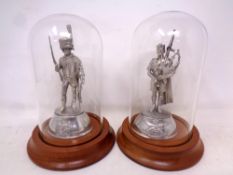 Two English pewter figures of soldiers under glass domes.