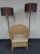 A wicker conservatory armchair together with two contemporary floor lamps with shades