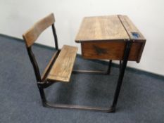 An early 20th century oak and metal school desk with integrated seat